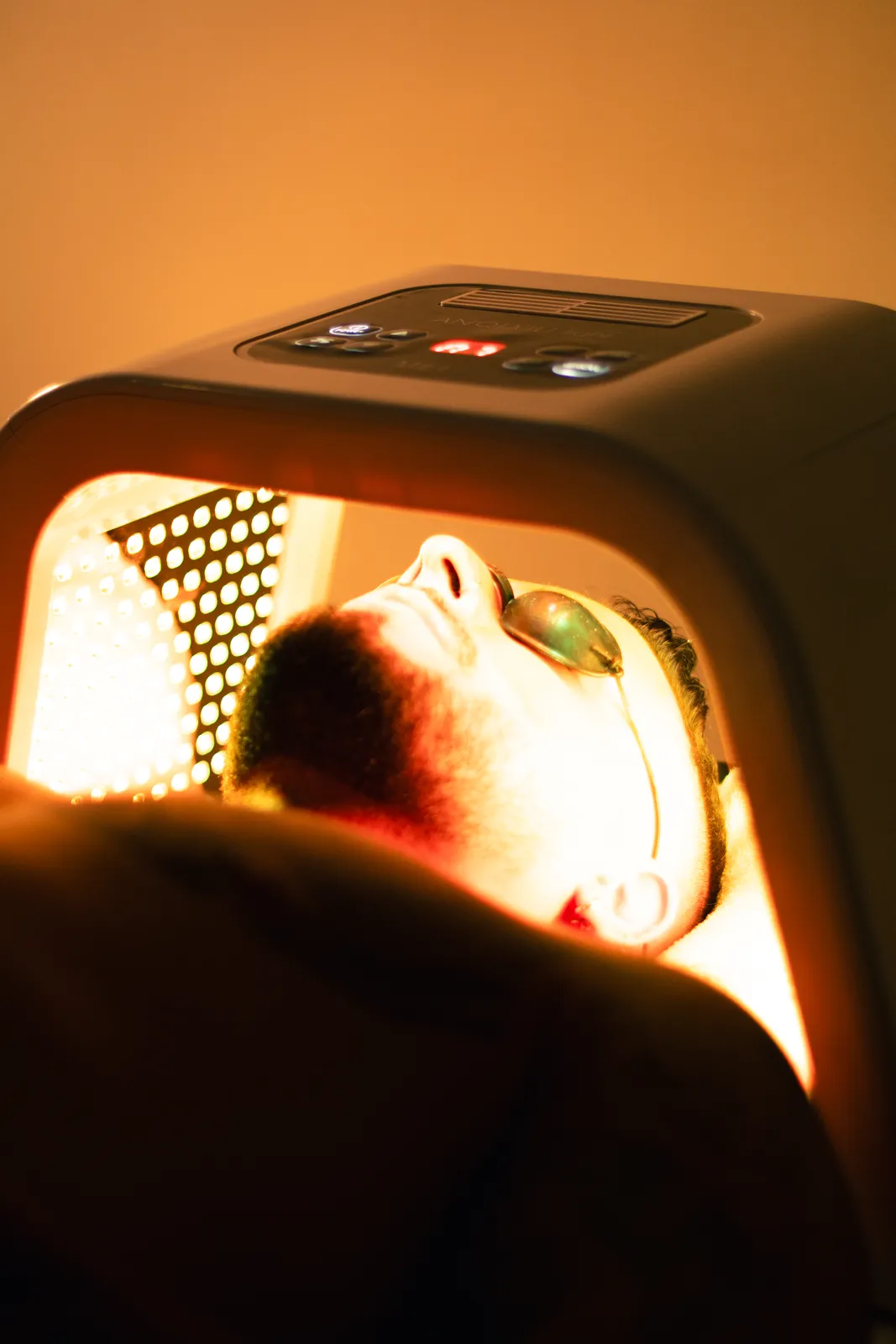Man relaxing beneath a warm light therapy lamp